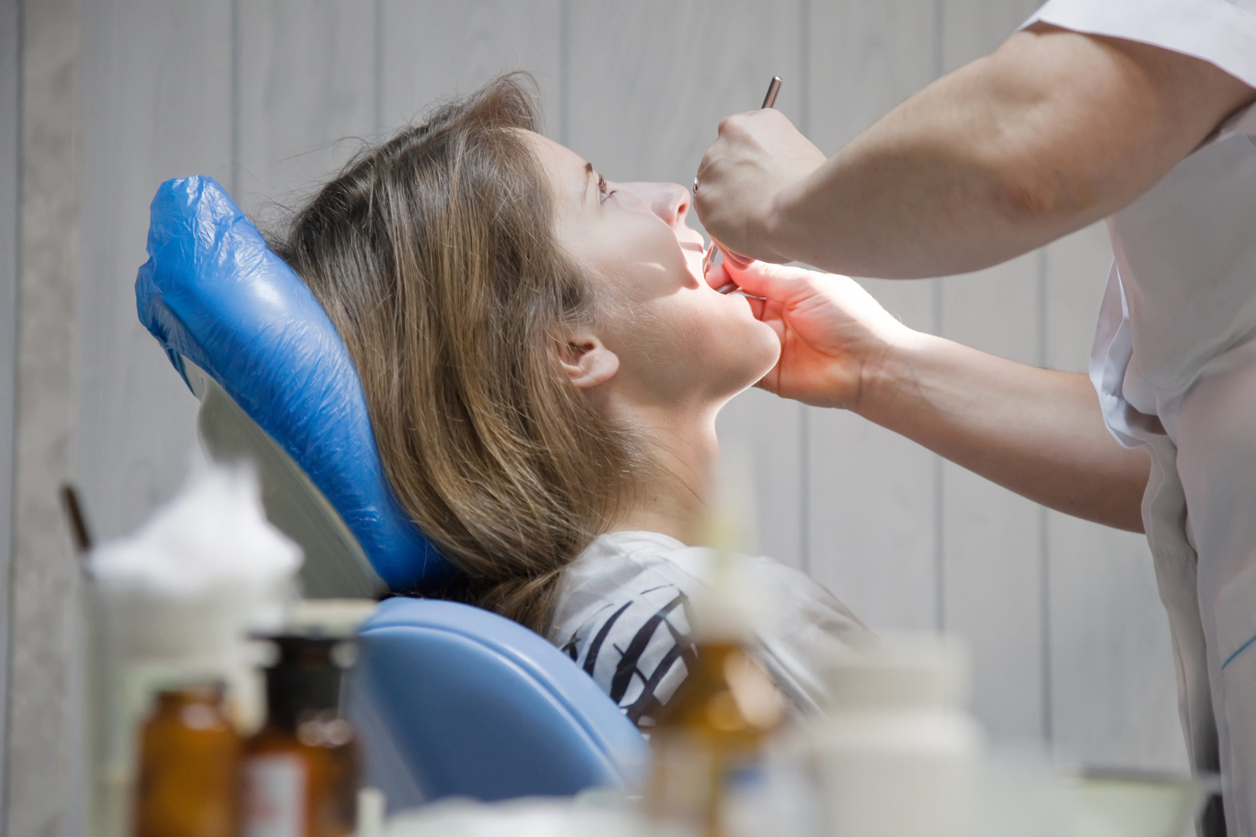 Dental checkup Teeneger girl during inspection of oral cavity with help of hook and mirror