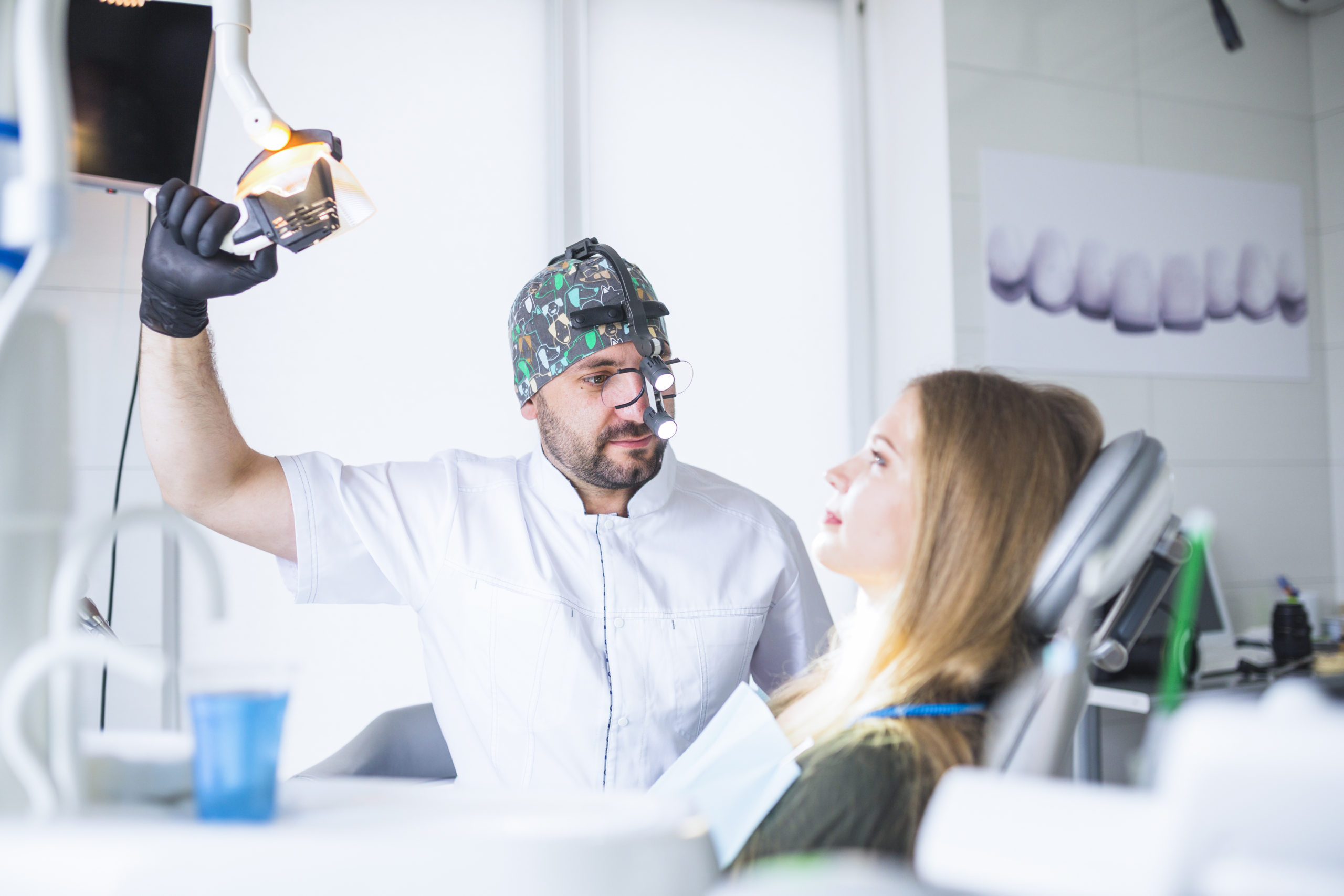 dentist-wearing-dental-loupe-binoculars-treating-female-patient dentist-wearing-dental-loupe-binoculars-treating-female-patient